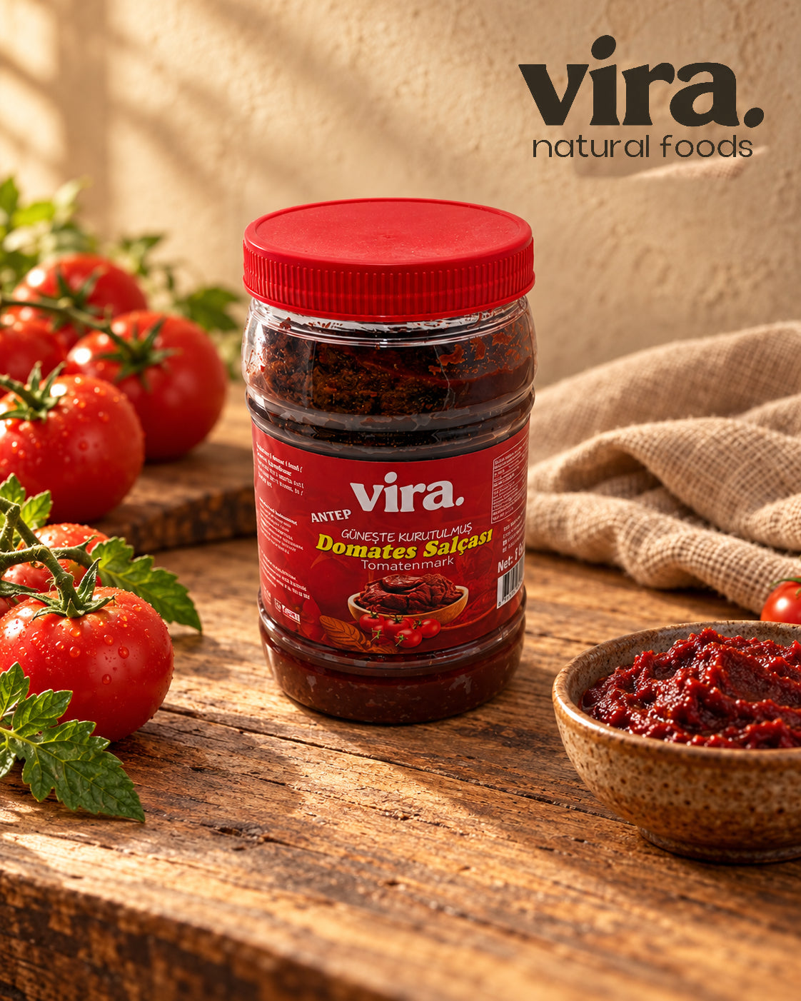 vira. sonnengereiftes Tomatenmark nach Antep-Art 1000 g in Dose mit rotem Deckel neben frischen Tomaten