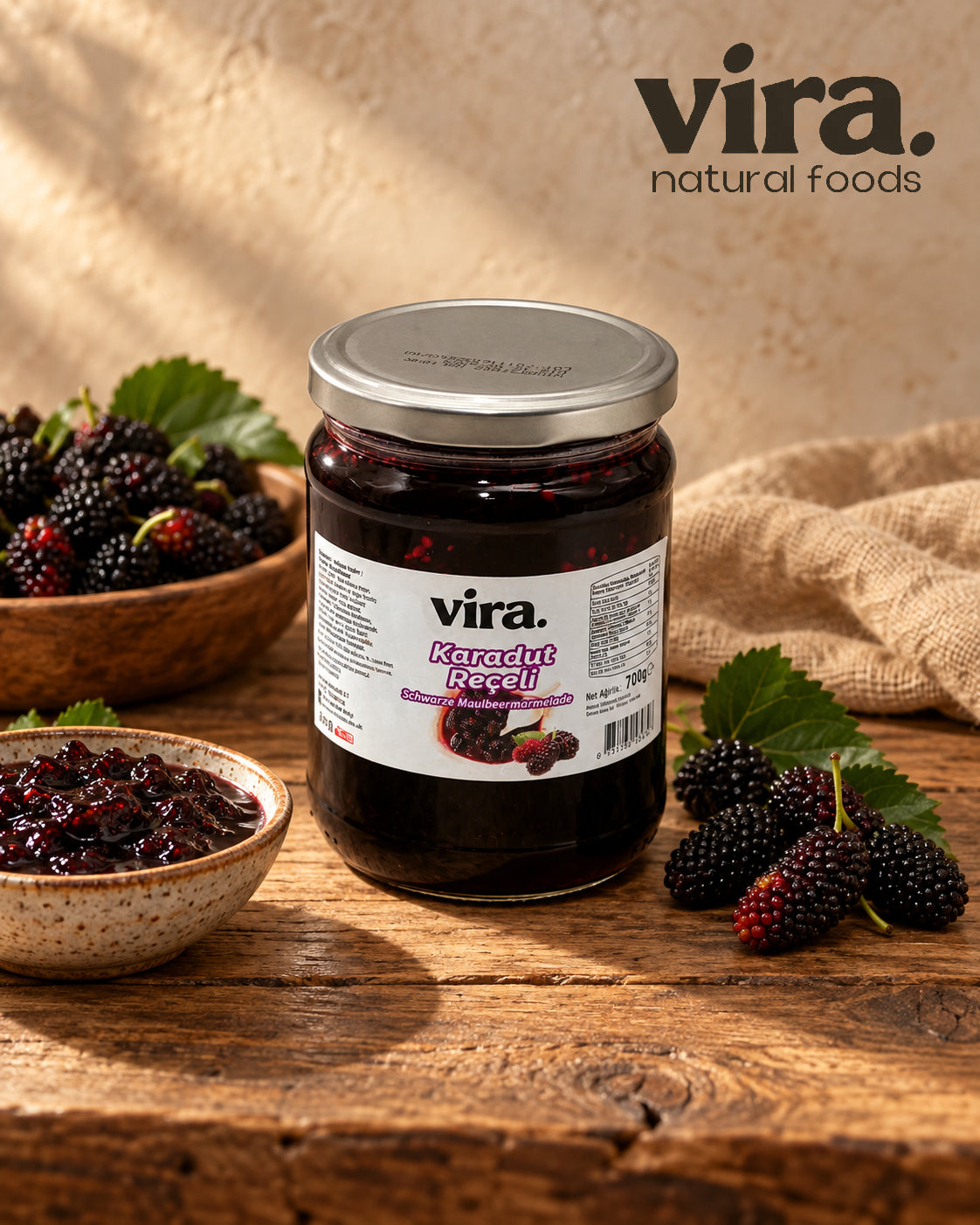 vira. Schwarze Maulbeermarmelade im 700-g-Glas mit frischen schwarzen Maulbeeren auf Holztisch
