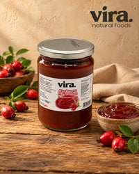 vira. Hagebuttenmarmelade 700g im Glas mit frischen Hagebutten und Schale Marmelade auf Holztisch