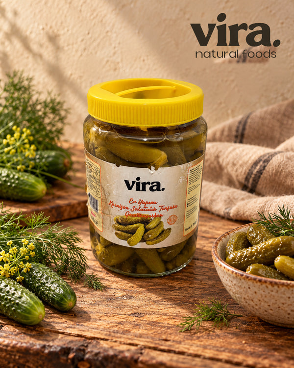 vira. Gewürzgurken nach Hausmacher Art im 1-kg-Glas mit gelbem Deckel, daneben frische Gurken und Dill