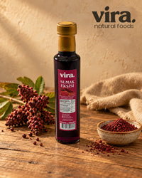vira. Sumach-Sauce 250ml in Glasflasche mit Sumachfrüchten und Sumachpulver auf Holztisch